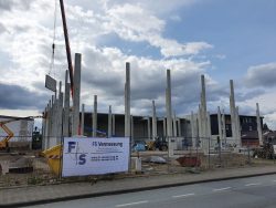 Firmenbanner am Bauzaun eines Hallenneubaus