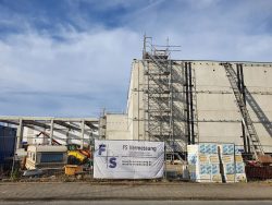 Firmenbanner am Bauzaun eines Hallenneubaus